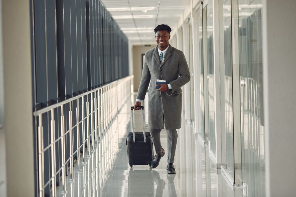 Traveler walking through an airport terminal with a suitcase and passport, representing Dubai visa renewal and expat travel documentation