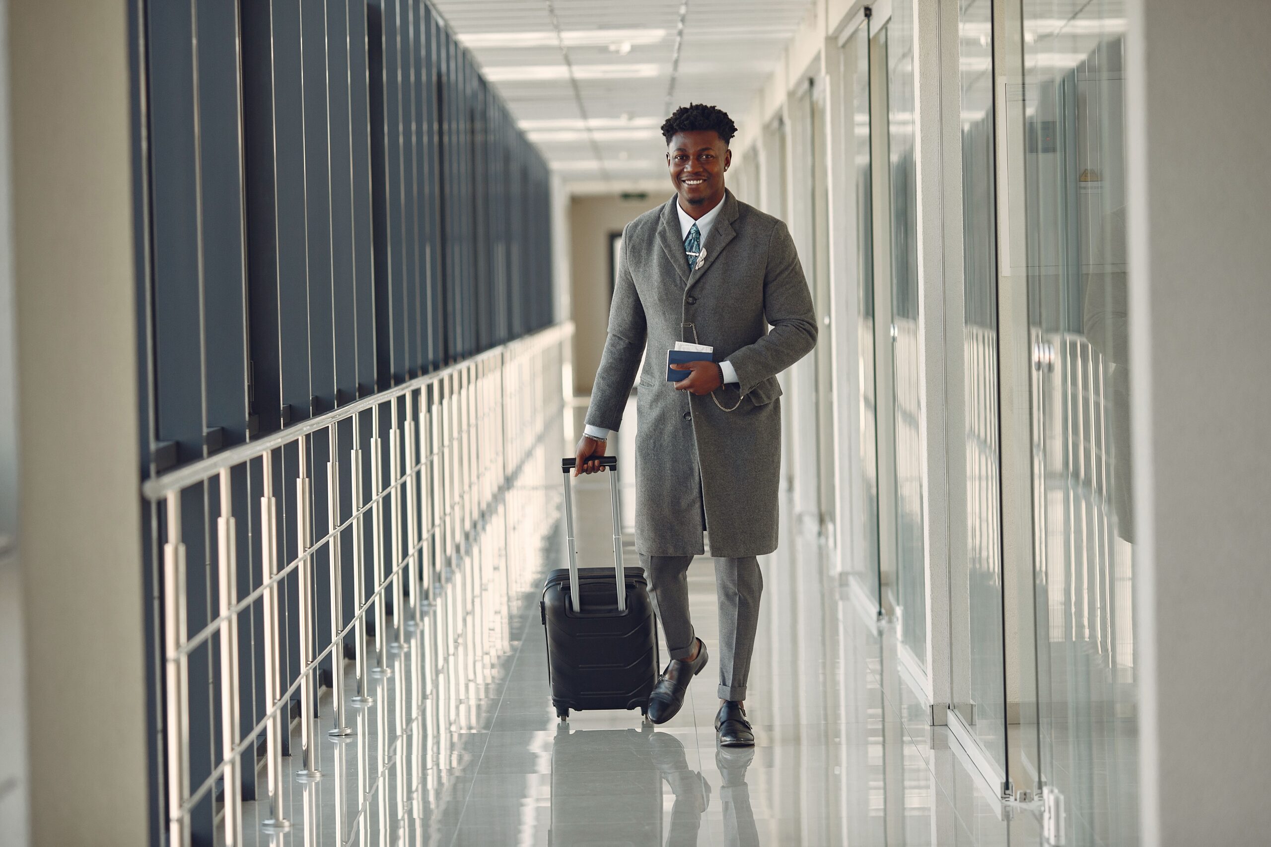 Traveler walking through an airport terminal with a suitcase and passport, representing Dubai visa renewal and expat travel documentation
