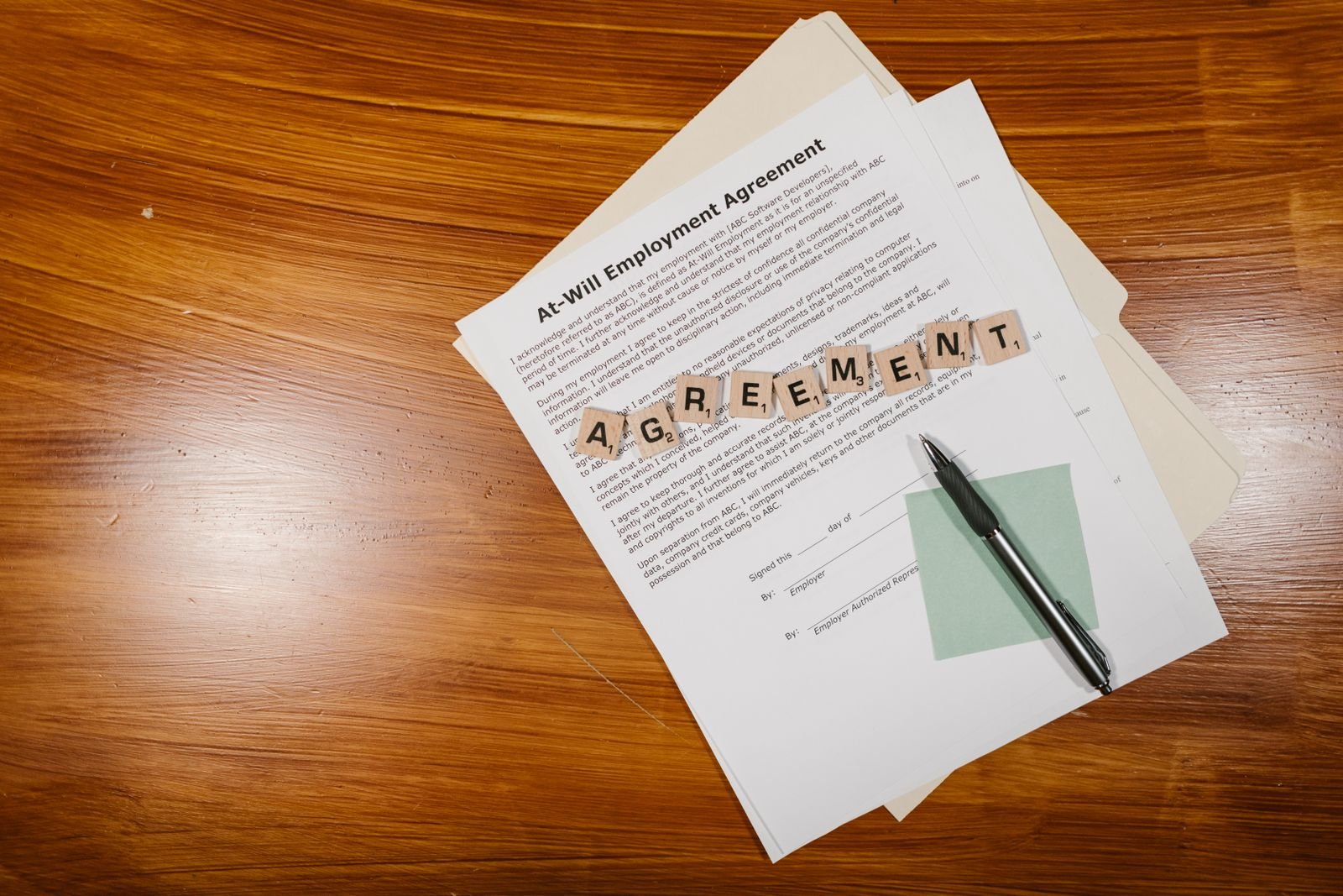 Employer and employee reviewing and signing an employment contract in a UAE office