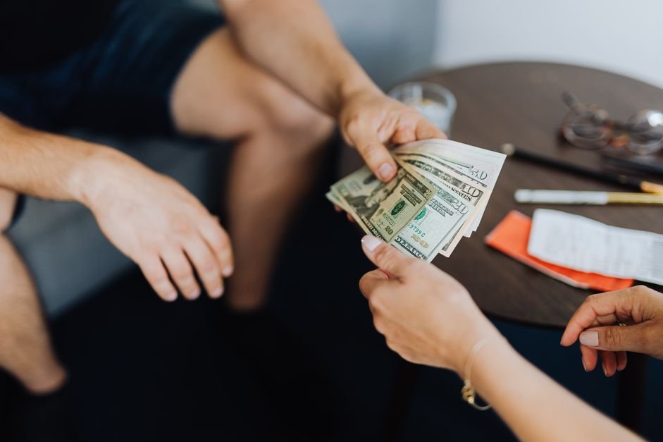 Hands exchanging money, representing UAE end of service gratuity payment to an employee