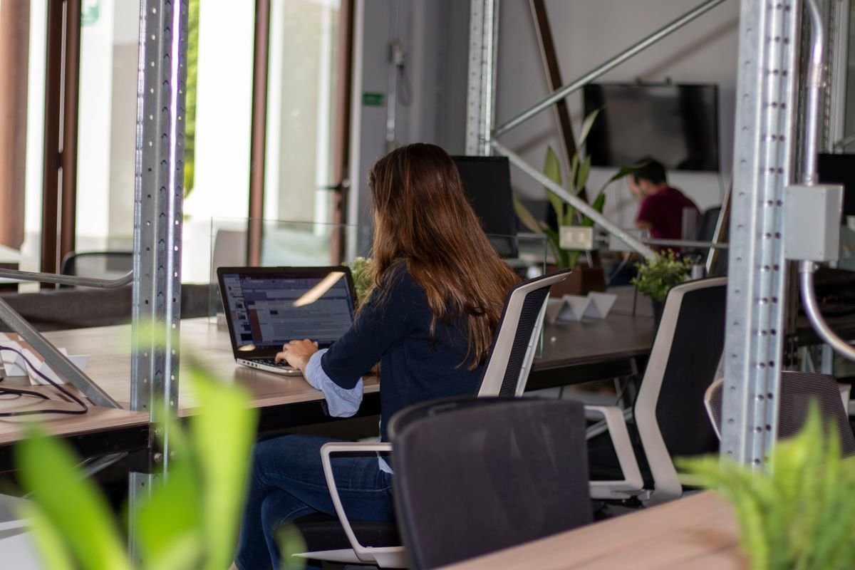 Woman working on a laptop in a coworking space representing freelance work in Dubai