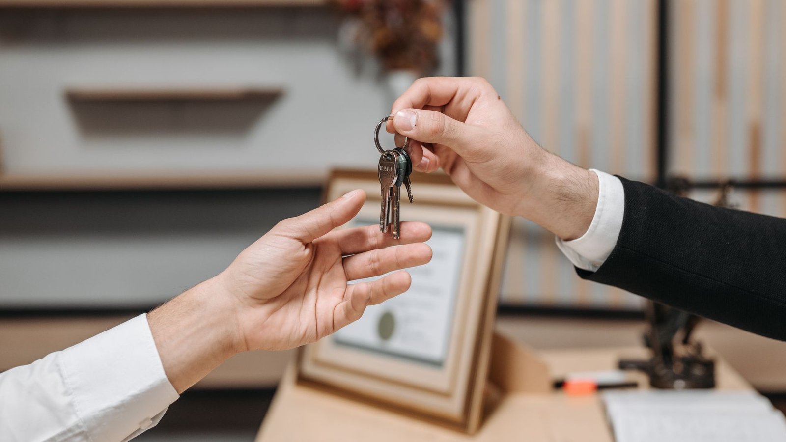 A person handing over house keys, representing Ejari tenancy contract registration in Dubai