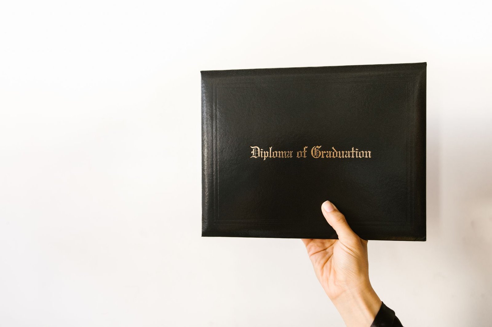 Close-up of a hand holding a graduation diploma, representing UAE degree certificate equivalency and attestation