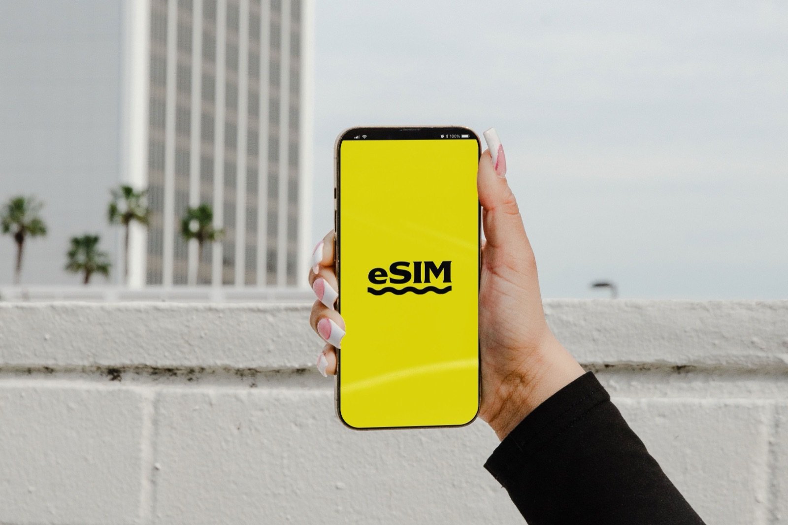 Hand holding a smartphone displaying a SIM card screen, representing UAE mobile SIM registration for new residents
