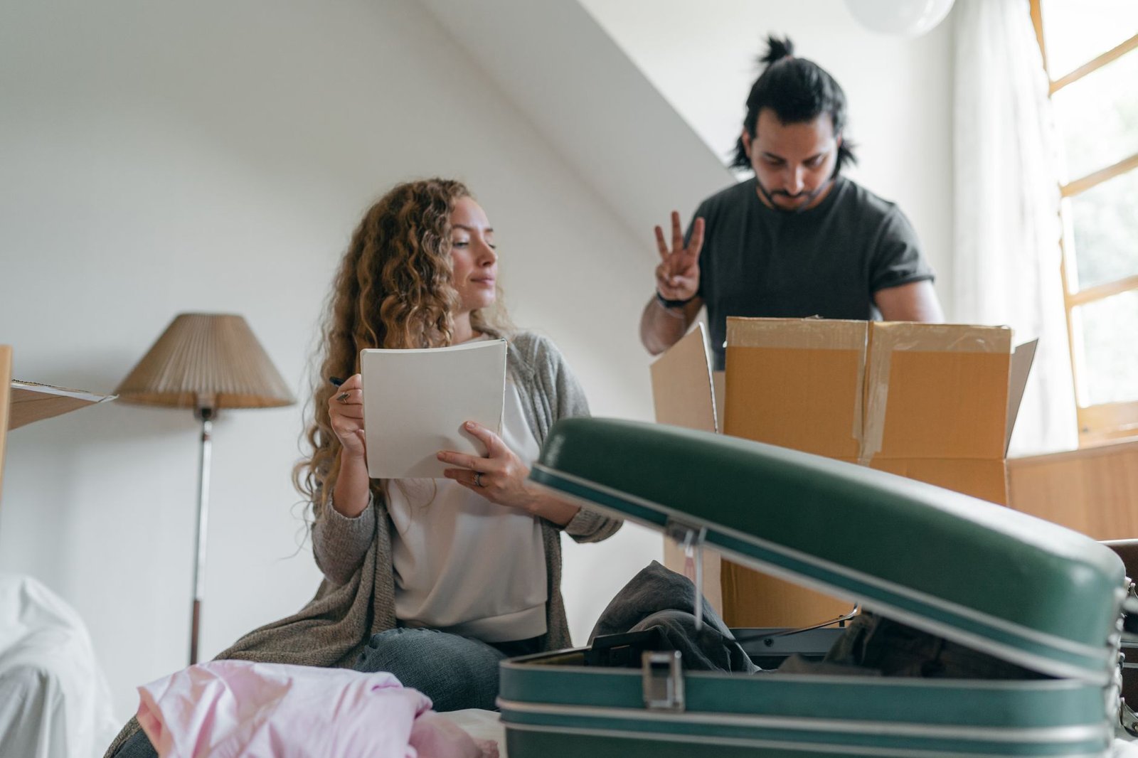 Couple packing belongings into boxes and suitcases, representing leaving the UAE for good