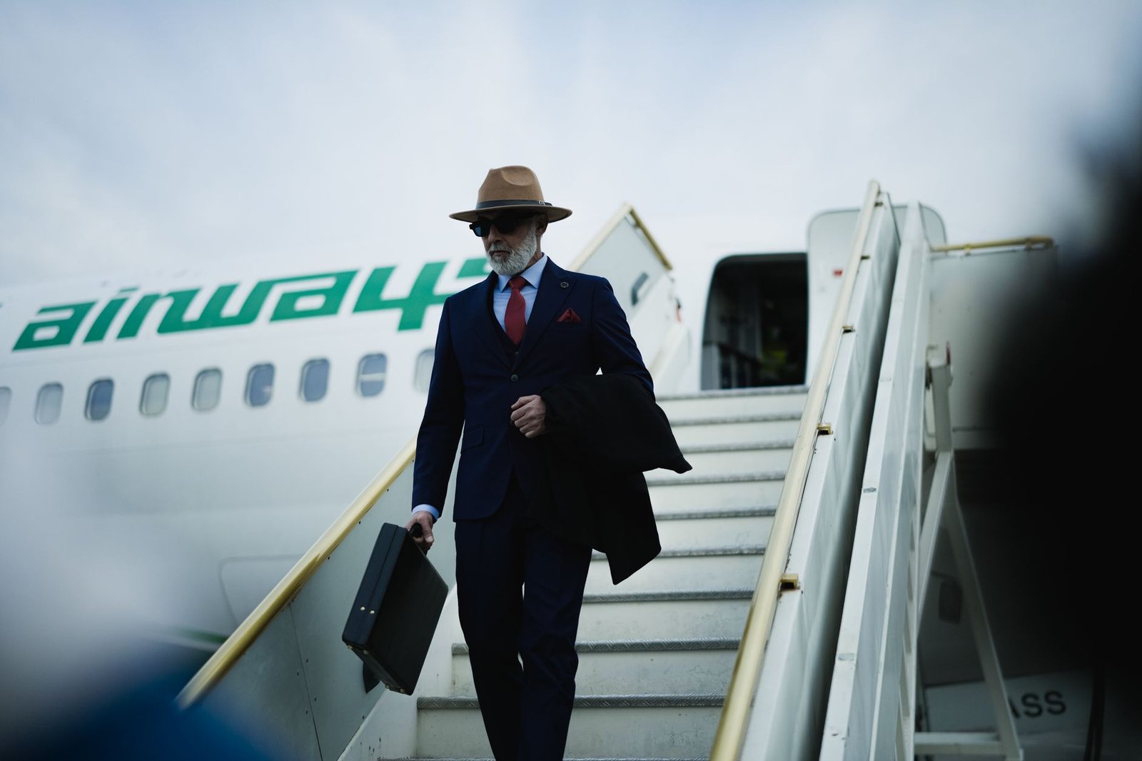 Businessman with a briefcase stepping onto an airport tarmac, representing a UAE business visit
